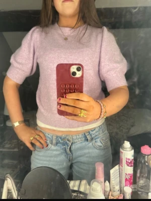 Ljuslila stickad kortärmad tröja - Superfin ljuslila stickad tröja med korta ärmar. Tröjan har en croppad passform och är perfekt att styla med jeans eller kjol. Mjuk  , skön och supergullig! Nästan inget använd säljer då den bara inte kommer till använding🥰lite smånopprig men inget man tänker på🙌