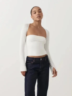 Vit långärmad croppad topp från Gina  - Snygg vit croppad topp från Gina tricot med långärmade ärmar och offshoulder-design. Toppen har en stilren och modern look med tight passform och är tillverkad i ett stretchigt syntetmaterial. 