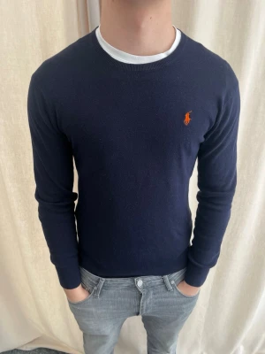 Mörkblå tröja från Ralph Lauren - Riktigt snygg stickad tröja från Ralph Lauren. Strl S, personen på bilden är 184 cm lång. Skicka gärna prisförslag. Kika in min profil för liknande plagg