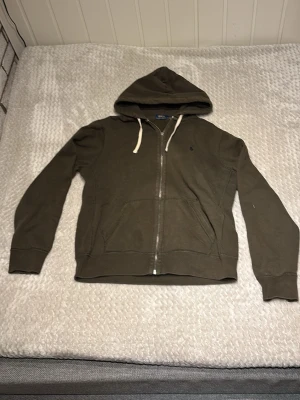 Mörk Grön Ralph Lauren zip up - Säljer denna riktigt sjysta zip upen från RL | Skicka 6/10 | Storlek: L | Drag kjedjan är sönder men annars riktigt najs | Pris kan diskuteras vid snabb affär🤝