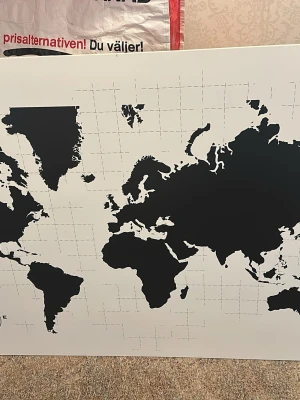 Helt ny stor världskarta i svartvitt tavla - Snygg och stilren världskarta i svart och vitt med tydliga kontinenter och rutnät. Perfekt som väggdekoration för att ge rummet en modern och internationell känsla. Kartan är tryckt på en stor, platt yta och passar bra i hemmet eller på kontoret.   66,5 x 96 cm 