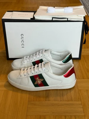 Gucci Ace Bee sneakers - Mycket fina vita Gucci Ace Bee Sneakers. Har endast använt dem ett fåtal gånger så de är i princip nya. Storlek UK 7,5 vilket motsvarar EU/IT 42. Nypris ca 9300kr. Allt medföljer på köpet. Fraktas samma dag som köp!