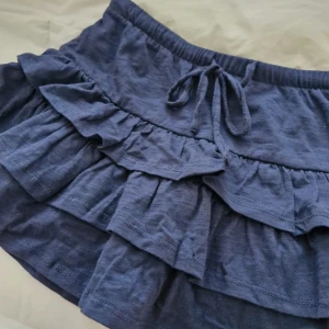 Blå volangkjol mini - super söt marinblå kjol från Gina Tricot. Säljer pågrund av att den var för liten för mig. Nypris 299 kr. Har bara använt en gång.