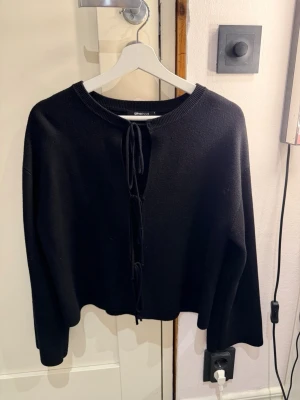 Svart stickad tröja Gina Tricot - Svart stickad tröja från Gina Tricot med långa ärmar och knytning framtill💕Aldrig riktigt kommit till användning