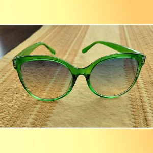 Gröna retro solglasögon i plast - Snygga solglasögon med transparent grön båge och stora, runda glas. Perfekt accessoar för dig som vill sticka ut med en färgglad och trendig look. Bågarna är i plast och har en cool retrovibe.
