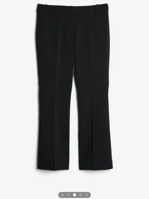Svarta kostymbyxor med pressveck - Stilrena svarta kostymbyxor med bootcut ben. Perfekta för en clean och klassisk look. Materialet är mjukt och bekvämt.