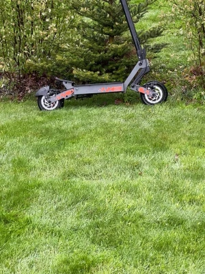 Kukirin g2 - Säljer en grå elsparkcykel från Hikerboy med robust ram i metall och detaljer i lila och rött. Utrustad med stora hjul och bred fotplatta för extra stabilitet. Perfekt för att ta sig fram snabbt och smidigt i stan eller till skolan.