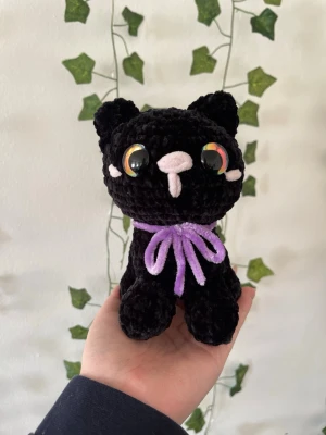 Virkad svart katt med lila rosett - Handvirkat i mjukt polyester garn! Perfekt som gosedjur eller present!