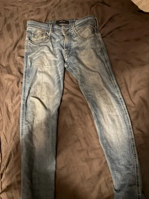 Replay ljusblå slim fit jeans - Snygga ljusblå jeans från Replay med slim fit passform. Jeansen har klassisk femficksdesign, slitningar och snygga detaljer på bakfickorna. Tillverkade i denim med en skön stretch för extra komfort.