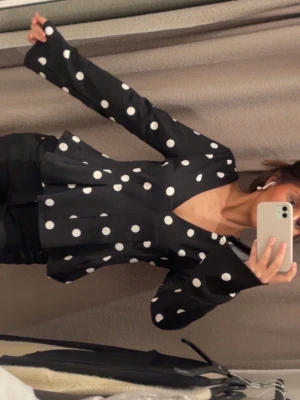 Svart prickig blus med v-ringning - Trendig svart blus med vita stora prickar och djup v-ringning. Använd 2 gånger och säljer den eftersom att den inte passar mig då jag är en S💕öppen för prisförslag och skriv om ni vill ha fler bilder eller har frågor, svarar väldigt snabbt💕