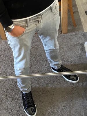 Ljusgrå jeans från Replay - Snygga ljusgrå jeans från Replay med klassisk femficksdesign och coola kontrastsömmar på bakfickan. Jeansen har en patch med Replay-logga bak i midjan och är tillverkade i mjukt denimtyg. Perfekta för en avslappnad och trendig look.
