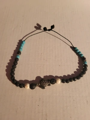 Lavastone bracelet  - This handmade bracelet features a turtle charm, lava stones, unidentified white stones, and turquoise or turquoise imitation (Unfortunately I do not remember. I think they are real, but I cannot be sure). It has adjustbility via draw strings so it can fit almost any wrist. Bundle discounts: two items 5% off (automatic) three items 10% off, five items 20% off. Message me before purchasing 3+ items for discount.