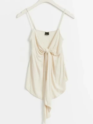 Krämvit linnetopp med knyt framtill - Säljer en krämvit linnetopp med smala axelband och snygg knyt-detalj framtill. Toppen har en avslappnad passform och är tillverkad i mjukt material som känns skönt mot huden. Perfekt för varma dagar och enkel att styla med jeans eller kjol.