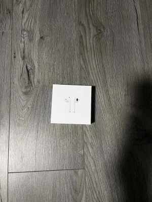 Apple AirPods med laddningsetui - Säljer ett par vita Apple AirPods med laddningsetui. Trådlösa in-ear hörlurar i stilren design, perfekt för musik, samtal och poddar. Kommer i originalförpackning. Klassisk Apple-kvalitet och smidig anslutning till iPhone och andra enheter.