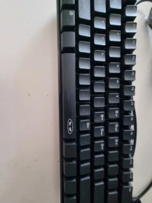 Svart tangentbord och musmatta - Säljer ett svart tangentbord med klassisk design och vita tecken på tangenterna. Medföljer en svart musmatta med vitt abstrakt mönster, perfekt för gaming eller kontor. Tangentbordet har USB-anslutning och musmattan har sydda kanter för extra hållbarhet.