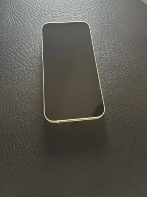 Vit iPhone 13 - Snygg vit iPhone med minimalt slitage, fungerar helt förutom batteriet som är lite sämre men fungerar fortfarande då den är på 86%. Har 128GB så mycket plats
