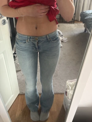 Ljusblå bootcut jeans - Säljer ett par ljusblå bootcut jeans med klassisk femficksdesign och normal midja. Jeansen har en snygg tvättad look och är tillverkade i mjukt denimtyg. Perfekta för dig som gillar retrovibbar och vill ha ett par jeans med utsvängda ben.