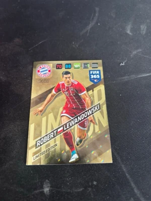 FIFA 365 Limited Edition samlarkort Lewandowski - Samlarkort från Panini FIFA 365 Limited Edition med motiv av fotbollsspelaren Robert Lewandowski i Bayern Münchens röda matchställ. Kortet har guldfärgad bakgrund och detaljer, samt spelarstatistik och klubbmärke. Perfekt för dig som gillar fotboll och samlarobjekt.