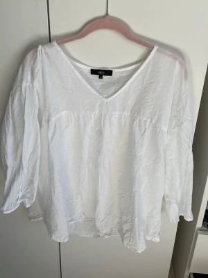 Vit v-ringad blus från Ellos - Säljer en luftig vit blus från Ellos i storlek 38. Blusen har v-ringning, lång ärm och är tillverkad i ett tunt, mjukt tyg som känns skönt mot huden. Perfekt till jeans eller kjol för en fräsch look.