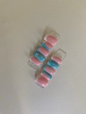 Press-on naglar rosa och blå swirl - Snygga press-on naglar i en mix av ljusrosa och blått med swirl-mönster. Naglarna har en oval form och en glansig finish som ger en trendig look. Perfekt för dig som vill ha en färgglad och unik nageldesign utan att behöva gå till salong.