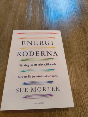 Energikoderna av Sue Morter - Boken 'Energikoderna' av Sue Morter är en inspirerande skönlitterär bok. Den handlar om sju steg för att vakna, läka och leva ett liv du inte trodde fanns. Perfekt för dig som vill utforska personlig utveckling.