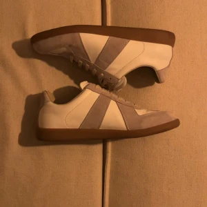 Maison Margiela Gats - Vita GATs från Maison Margiela med beige mockadetaljer och klassisk gum sole.