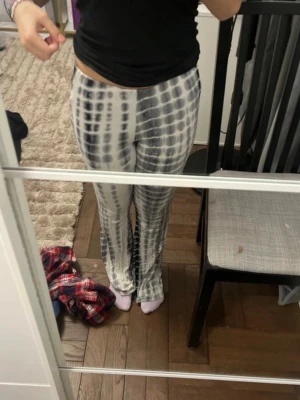 Gråvita tie-dye leggings - Säljer ett par stretchiga leggings med gråvitt tie-dye mönster. De har hög midja och långa ben med en smal passform som sitter snyggt. Perfekta för dig som gillar en avslappnad men trendig stil.