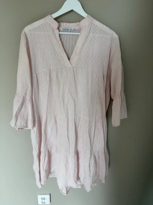 Strandklänning - Vit- och rosaranding standklänning från Copenhagen Luxe. I storlek S/M. I mycket bra skick, endast använd en gång.