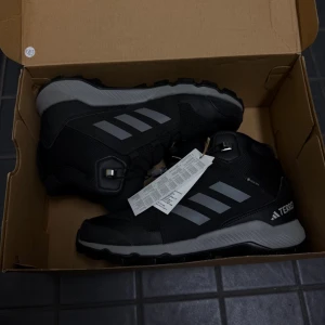 Säljer ett par Adidas Terrex Mid GTX K i nyskick – Size 37 1/3 EU - Skorna är helt nya, endast testade. Inga synliga skador eller slitage.  Utrustade med Gore-Tex för vattentäthet och bra grepp från Continental-sula. Originalkartong medföljer.  Size: 37 1/3 EU 🏷️ Rabatt vid köp av flera par skor!
