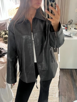 Svart oversized skinnjacka - Säljer en svart oversized skinnjacka med raka ärmar och dragkedjor vid ärmslut och fickor. Jackan har en klassisk krage och stilren look som passar till många outfits. Den är sparsamt använd och köpt från NAKD 🥰 nypris 800kr, villig att förhandla priset 