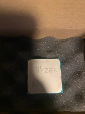 AMD Ryzen 5 2600 processor - Säljer en AMD Ryzen 5 2600 processor, perfekt för gaming och multitasking. Processorn har en silverfärgad metallhätta och blågrön kant, och passar till stationära datorer med AM4-sockel.