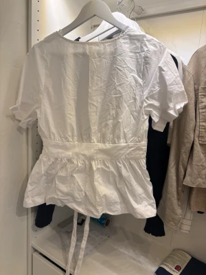 Vit blus med knytband i midjan - Snygg vit blus i skjort material. As snygg med band som man knyta både bak och fram. Säljer då jag inte använder den lika ofta längre🥹❣️skriv  för bild på eller för att diskutera pris!!!