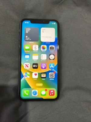 Svart iPhone 11 med dubbla kameror - Säljer en svart iPhone 11 med stilren design och rundade kanter. Telefonen har en 6,1-tums skärm, två bakre kameror och Apples logga på baksidan. Tillverkad i glas och aluminium, perfekt för dig som gillar snygg och modern teknik.