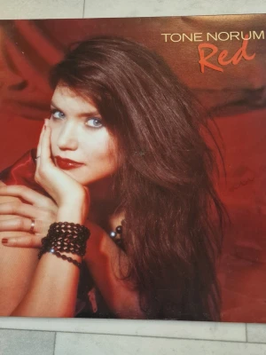 Tone Norum Red vinylskiva LP - Tone Norum Red vinylskiva LP. Albumet är i LP-format och omslaget visar låtlista på baksidan. Svag signering på omslaget.Passar för uppspelning på skivspelare som stödjer 33 1/3 rpm LP-skivor.