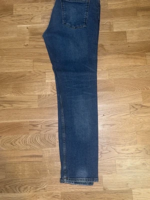 Pull and bear Mörkblå slim fit jeans - Ett par mörkblå slim fit jeans med klassisk femficksdesign och lätt slitning på låren. Jeansen har normal midja och smal passform hela vägen ner. Perfekta för en avslappnad och trendig look.