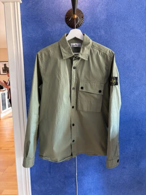 Grön overshirt från Stone Island - Overshirt från Stone Island. Köpt på NK och är självklart äkta! Inga defekter då den bara är använd fåtal gånger. 