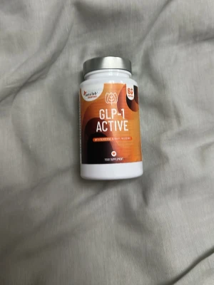 GLP-1 Active kosttillskott - Säljer en burk GLP-1 Active från Health Nutrition. Burken är vit med orange och svart etikett samt silverfärgat lock. Innehåller 24 kapslar och är ett kosttillskott. Perfekt för dig som vill testa något nytt inom hälsa och träning. Det hjälper till med att minska hungern och apatiten. 