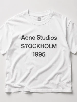 Vit Acne Studios t-shirt Stockholm - Säljer en klassisk vit t-shirt från Acne Studios med svart tryck 'Acne Studios STOCKHOLM 1996' på bröstet. T-shirten har rund halsringning och korta ärmar. Tillverkad i mjuk bomull för en skön och avslappnad look. Lapparna är bortklippta pga de skavde.