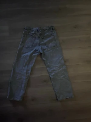 Blå raka jeans med hög midja - Säljer ett par klassiska blå jeans med raka ben och hög midja. Jeansen har två bakfickor och knappgylf. Perfekta för en avslappnad och trendig look. Materialet är denim i bomull från hm.