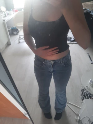 Blå bootcut jeans med hög midja - Säljer ett par ljusblå bootcut jeans med hög midja och klassisk femficksdesign. Jeansen har en lätt tvättad look och är tillverkade i mjukt denimtyg. Perfekta för en avslappnad och trendig stil.