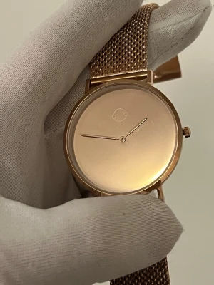Svensk märke damklocka. Roseguld meshklocka från cosmos Sweden  - Sjukt cool limited edition. Cosmos Sweden tillverkade bara få av dessa mirror Watch. Kommer i premium paket och klockan är 100% rostfritt, safir glass och Japan mekanism ! Först till kvarn. Stilren klocka från cosmos Sweden i roseguld med minimalistisk urtavla utan siffror och mesharmband i metall. Klockan har en rund form och en diskret logotyp på urtavlan. Perfekt accessoar för en clean look. 