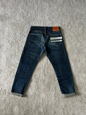 Blåa Momotaro Selvedge Jeans Storlek W30 L30 Straight Fit - Mycket fina Momotaro Jeans i blå färg. | Jeansen är i mycket bra skick och sparsamt använda. |  Äkta som allt annat jag säljer! ✅ |  Storlek: W30 L30 | Skick: Mycket Bra Skick - Har blivit avklippta vid benen (SE SISTA BILD)   | Färg: Blå | Märke: Momotaro | Modell: Jeans |   Hör gärna av dig vid frågor så svarar jag så fort jag kan! 😁 |  (SKU - 164)
