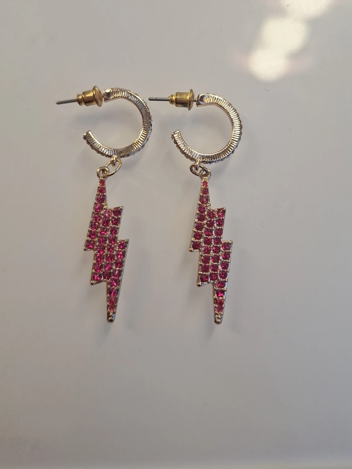 Guldörhängen med rosa blixtar