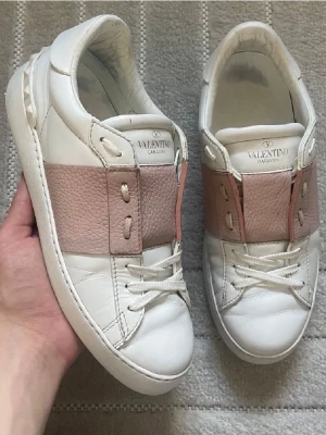 Valentino Garavani vita sneakers - Snygga vita sneakers från Valentino Garavani med breda ljusrosa läderdetaljer över snörningen. 