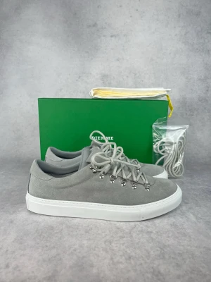 Grå mockasneakers från Diemme - Vi har skorna i storlek 40, 41, 41,5, 44,5, 45, 46 och 47. Stilrena grå sneakers från Diemme i mjuk mocka med vita, tjocka gummisulor. Skorna har unika metallöglor för snörningen och kommer med extra skosnören. Perfekta för dig som gillar minimalistisk och modern stil.