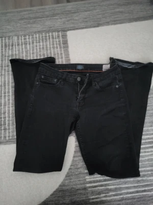 Bootcut jeans - Svarta bootcut jeans från Crockers. De är I ganska bra skick förutom den lilla delen längst ner på jeansen som är slitet, jag är 153 cm så de har suttit lite för långt ner på mig- det går nog däremot att sy upp de så det inte syns eller vika upp dem. Annars är de storlek 26/31.