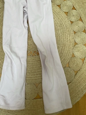 Ljusrosa utsvängda mjukisbyxor från Gina. - Supermjuka ljusrosa mjukisbyxor med utsvängda ben och dragsko i midjan. Perfekta för en chill och avslappnad stil. Tillverkade i ett mjukt och stretchigt material som känns skönt.