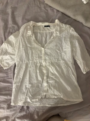 Vit blus med trekvartsärm  - Söt vit blus med trekvartsärmar och knappar framtill. 