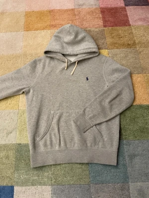 Grå hoodie från Polo Ralph Lauren -  Grå hoodie från Polo Ralph Lauren i storlek M och i bra skick. Skriv vid funderingar.