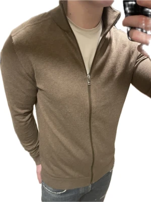 Brun stickad cardigan - Otroligt snygg brun stickad cardigan/full zip från Selected homme. Modellen är 180cm, 75kg. Priset kan såklart diskuteras!